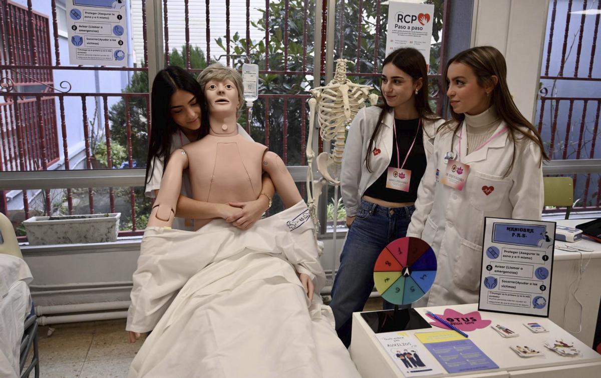 Alumnas del IES Martín Sarmiento explican sobre  la maniobra de Heimlich, durante la sesión de ayer. | RAFA VÁZQUEZ