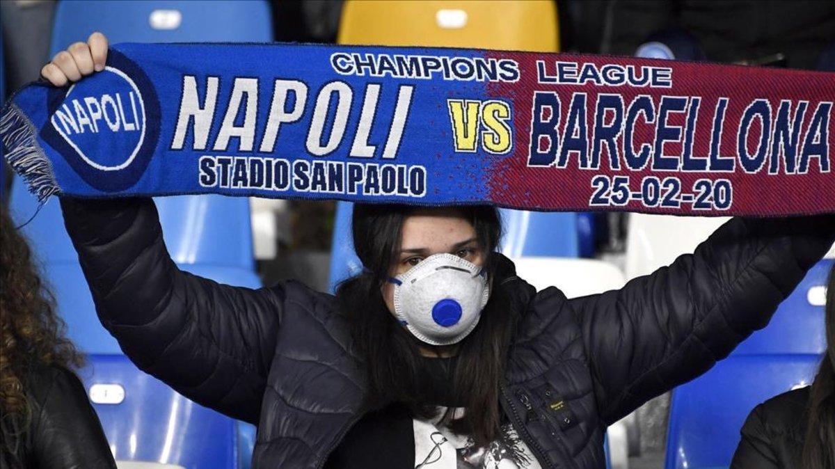Una mujer en la grada con máscara antes del partido