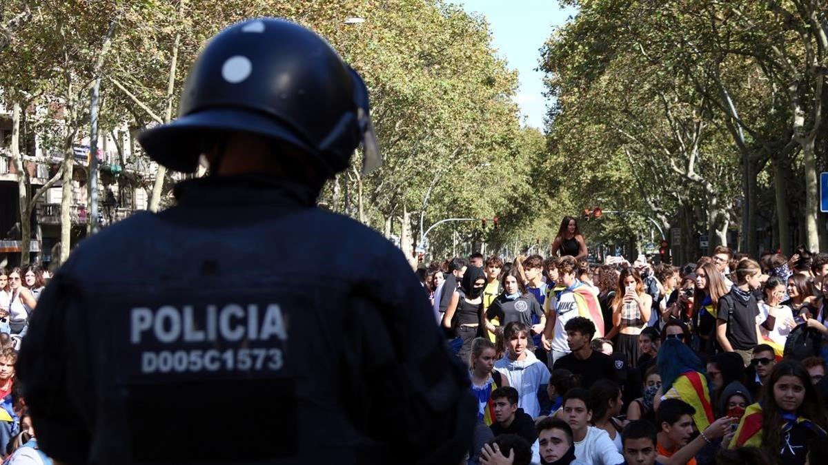 Un agente de policía, de espaldas, frente a unos manifestantes en la Gran Via de Barcelona, el 16 de octubre del 2019