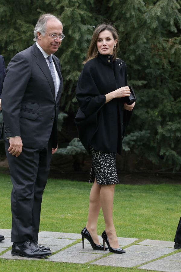 Letizia Ortiz con abrigo negro, falda estampada y stilettos negros