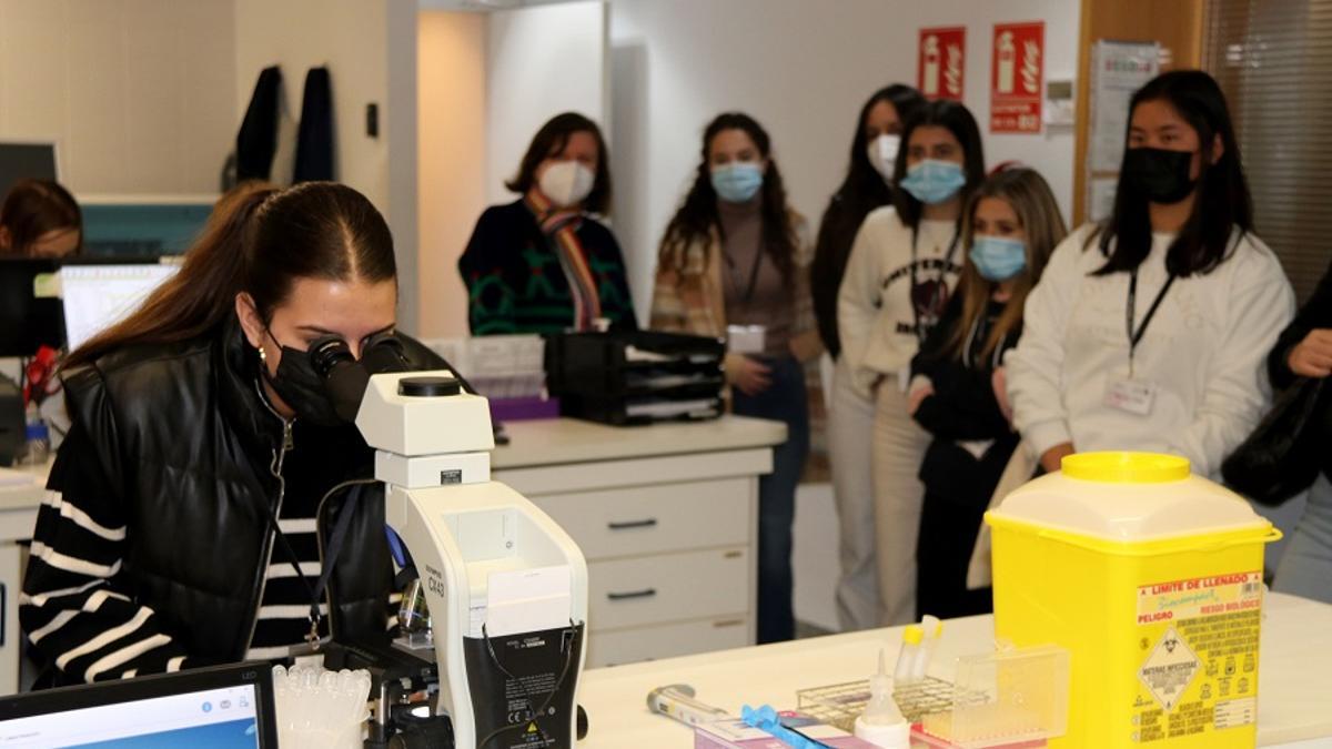 Una joven mira al microscopio en el laboratorio de Andrología