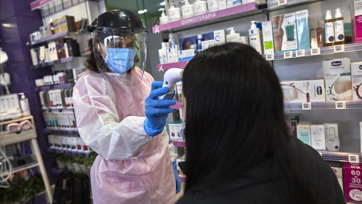 Una farmaceutica toma la temperatura a una mujer antes de realizarle un test de antigenos en la Farmacia Las Gemelas en Madrid (Espana)  a 11 de febrero de 2021  El pasado miercoles 3 de febrero  Salud Publica comenzo a mandar SMS para que los ciudadanos asintomaticos que residan en zonas con alta incidencia puedan acudir a estos centros y clinicas dentales a hacerse un test de coronavirus gratuitamente  Pontevedra ha comenzado esta semana un nuevo programa de pruebas en farmacias con el objetivo de extenderlo a toda Galicia  y en el caso de Barcelona ha concluido un proyecto piloto y trabaja su extension a toda Cataluna   11 FEBRERO 2021 FARMACIAS SANIDAD CORONAVIRUS PRUEBAS TEST CONTAGIOS PANDEMIAS  Jesus Hellin     Europa Press  11 02 2021