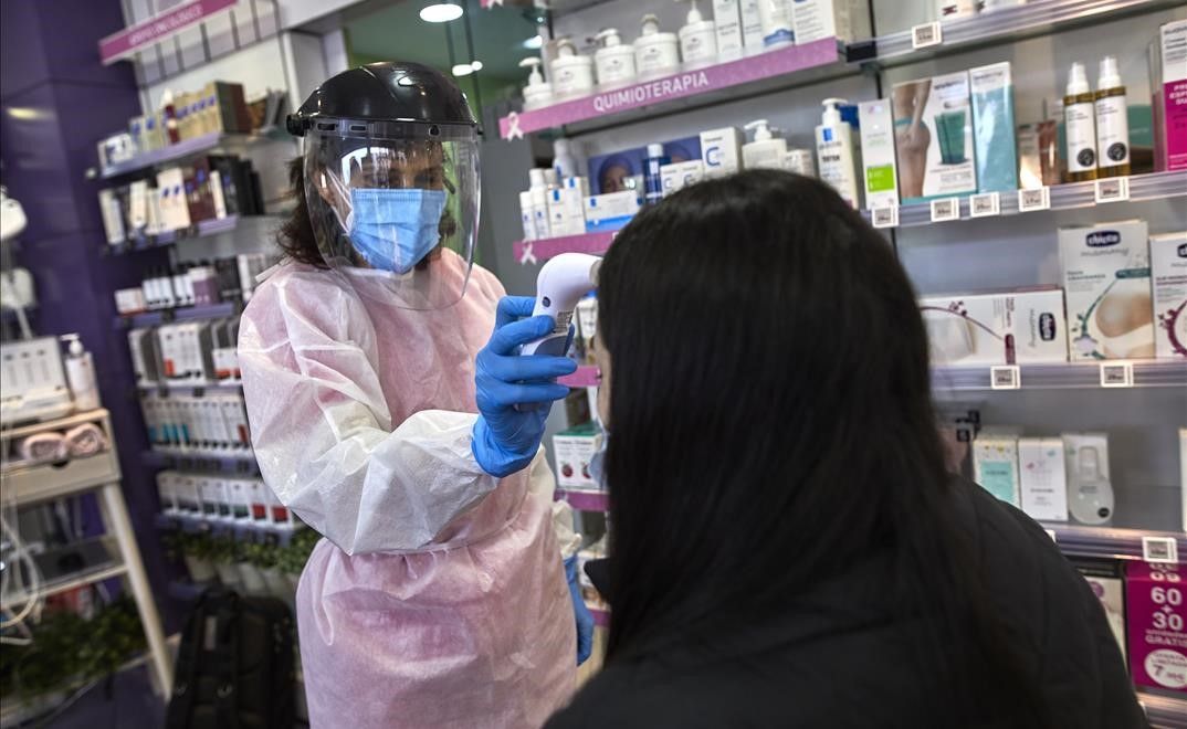 Una farmaceutica toma la temperatura a una mujer antes de realizarle un test de antigenos en la Farmacia Las Gemelas en Madrid (Espana)  a 11 de febrero de 2021  El pasado miercoles 3 de febrero  Salud Publica comenzo a mandar SMS para que los ciudadanos asintomaticos que residan en zonas con alta incidencia puedan acudir a estos centros y clinicas dentales a hacerse un test de coronavirus gratuitamente  Pontevedra ha comenzado esta semana un nuevo programa de pruebas en farmacias con el objetivo de extenderlo a toda Galicia  y en el caso de Barcelona ha concluido un proyecto piloto y trabaja su extension a toda Cataluna   11 FEBRERO 2021 FARMACIAS SANIDAD CORONAVIRUS PRUEBAS TEST CONTAGIOS PANDEMIAS  Jesus Hellin     Europa Press  11 02 2021