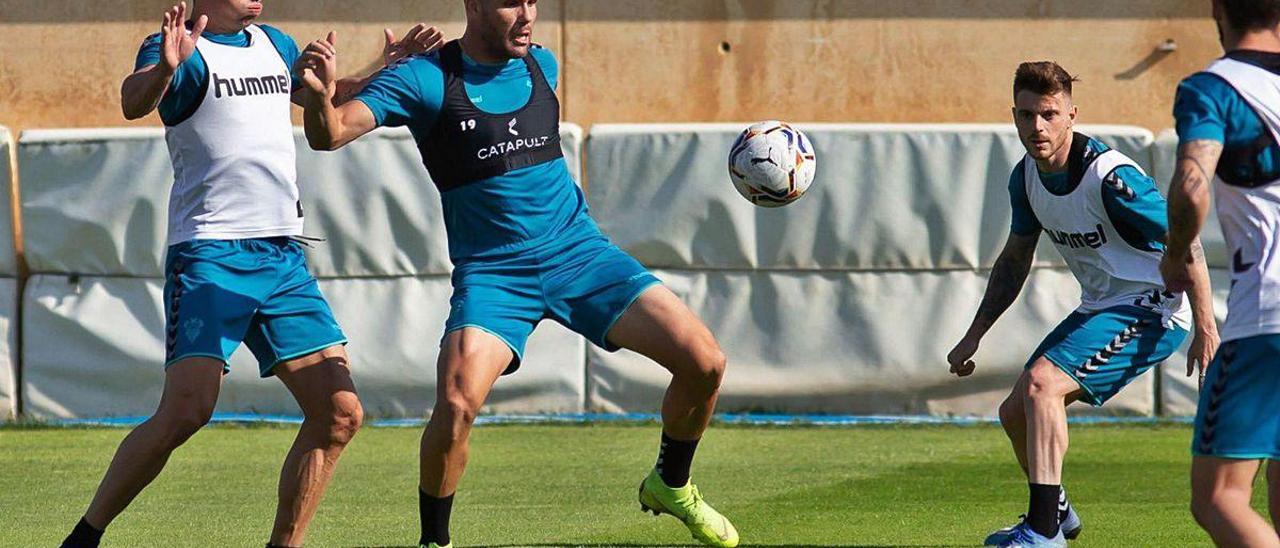 Ortuño se dispone a controlar un balón, rodeado de defensas manchegos en un entrenamiento.