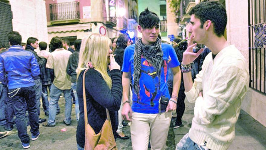 Un grupo de jóvenes, fumando a las puertas de uno de los pubs en el Casco Antiguo