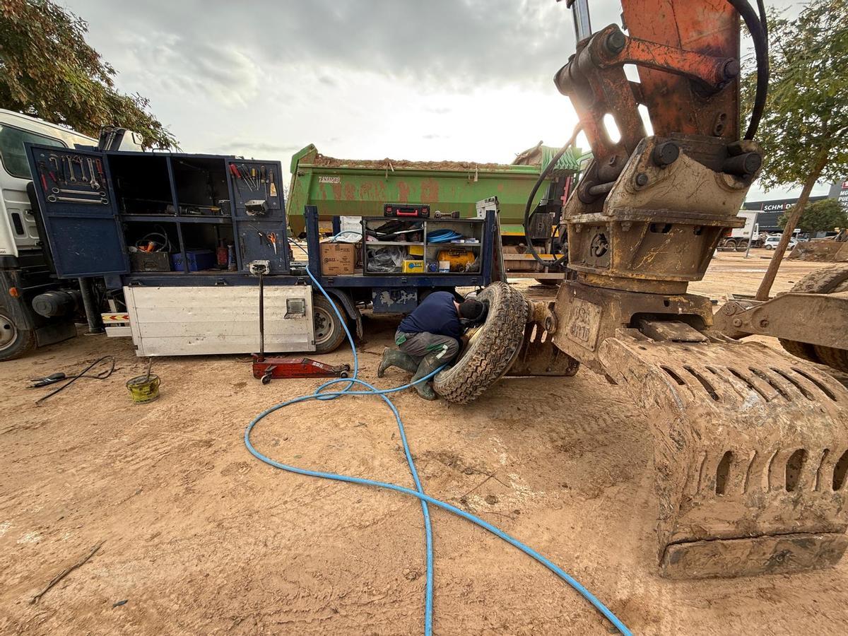 Un operario trabaja en la reparación de un gran neumático