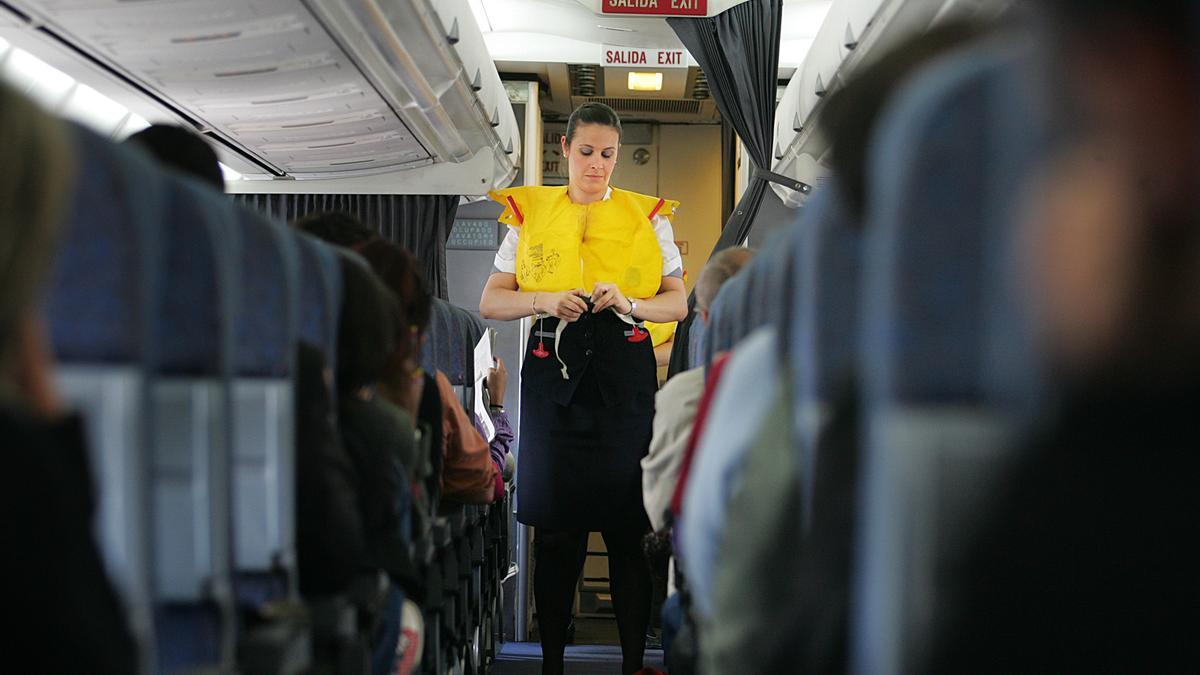 Una azafata de vuelo explica las normas de seguridad.