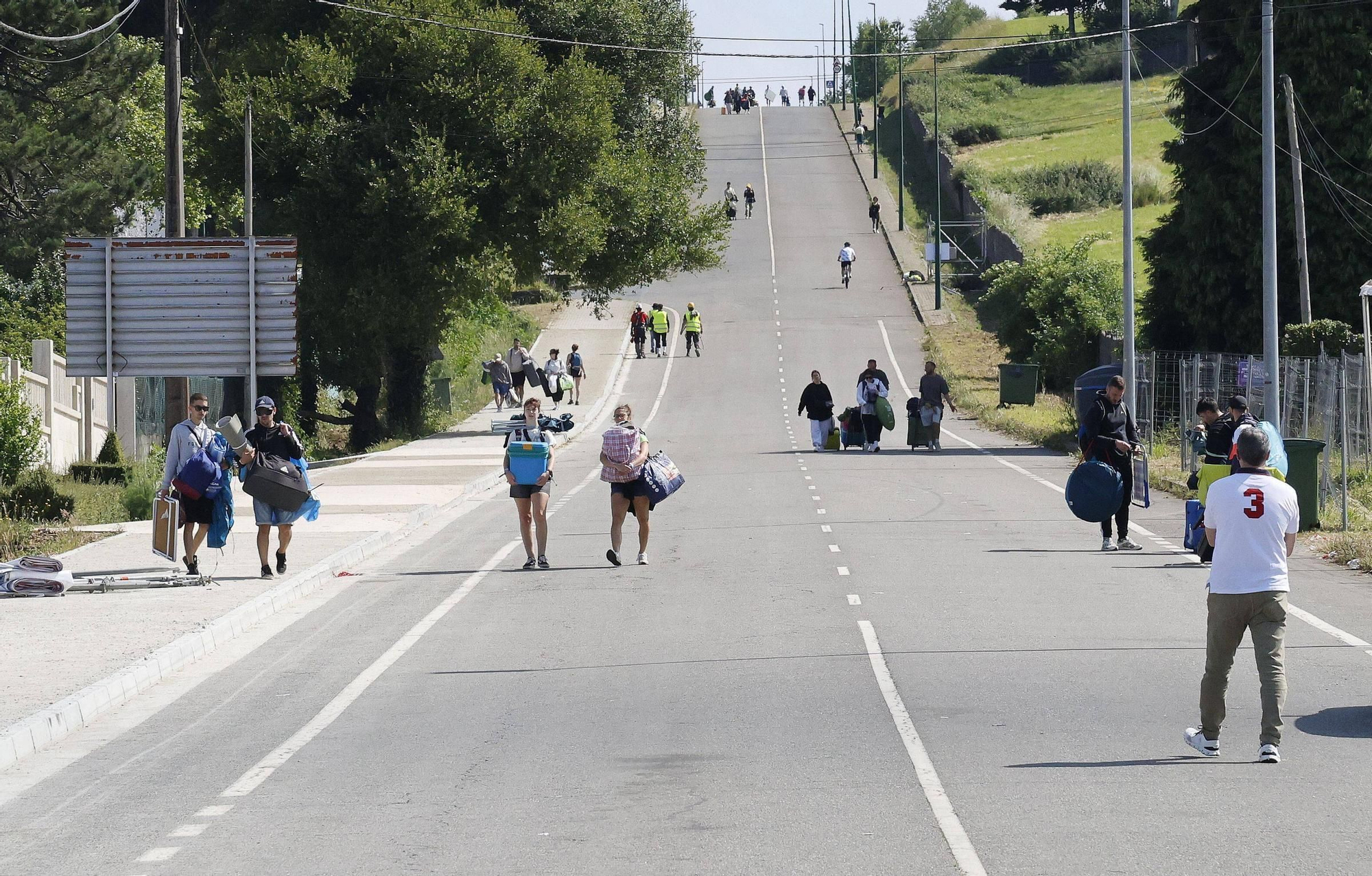 Vuelta a la realidad, paso a paso y mochila a cuestas: los campistas abandonan el Monte do Gozo