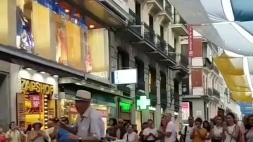 Un turista baila en Madrid bajo la bandera tricolor canaria