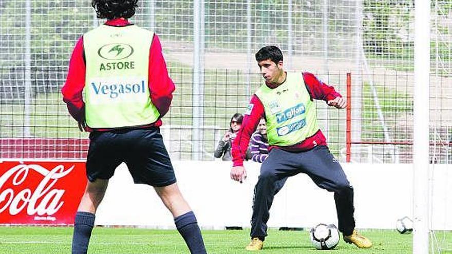 José Ángel controla un balón con Miguel de las Cuevas, de espaldas.