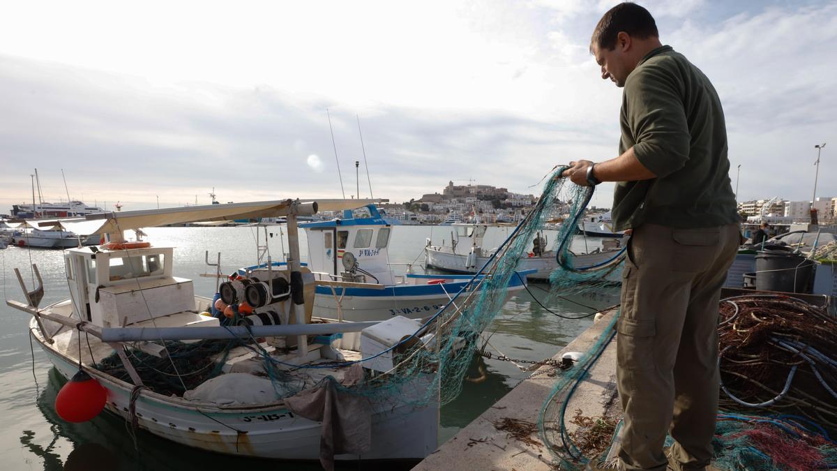 Un pescador artesanal prepara sus redes en el puerto de Ibiza.