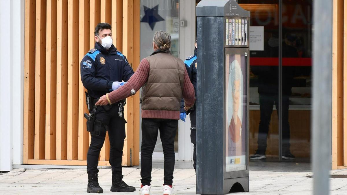 Agentes inquieren a una mujer sobre sus motivos para estar en la calle. // G. Santos