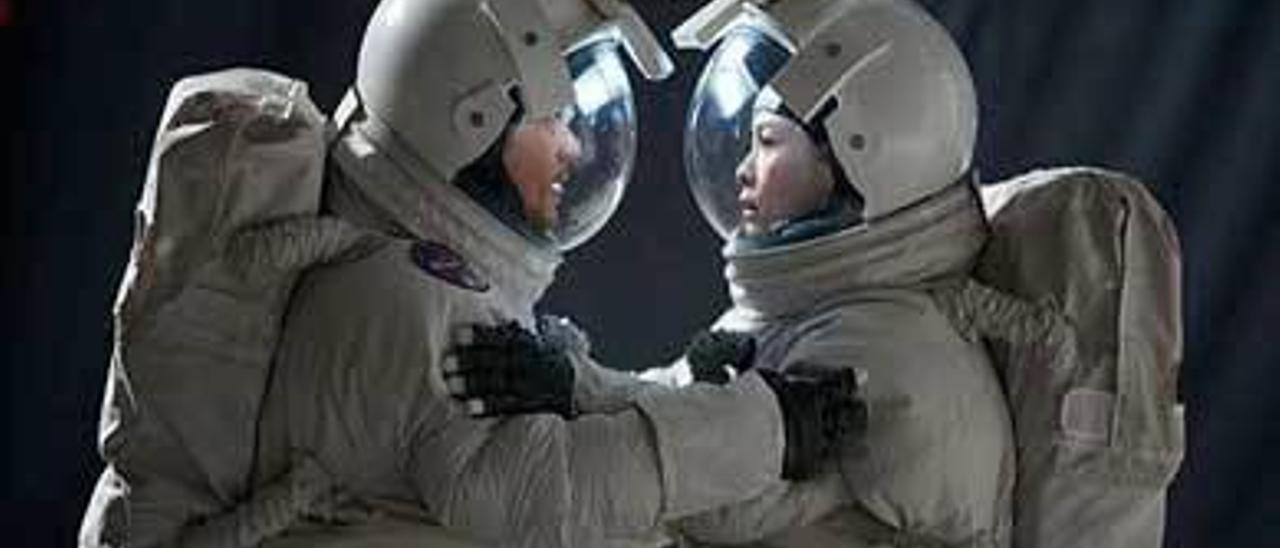 Una pareja, enfundada en trajes espaciales.