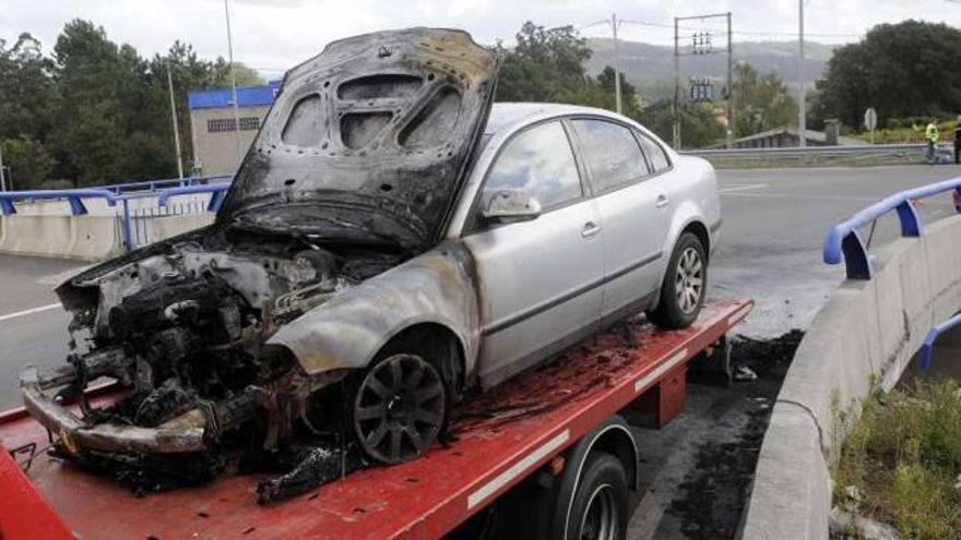 Traslado del vehículo incendiado en la rotonda de Godos-Baión. // Noé Parga