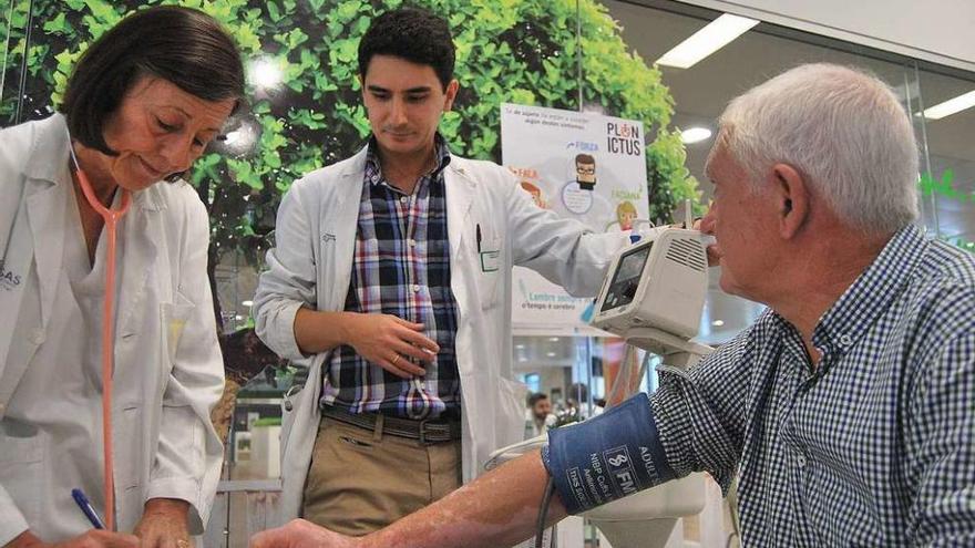 Miembros de Alento, la Asociación Galega de Neuroloxía y la Federación Galega de Dano Cerebral, en una mesa informativa.