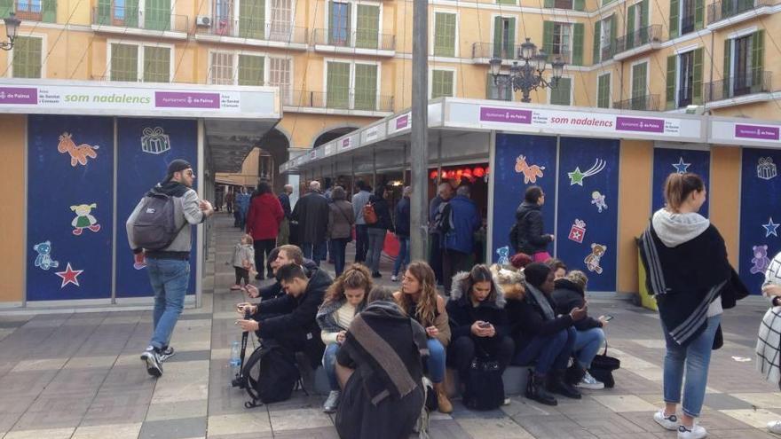 Un grupo de jóvenes franceses permanecían más atentos a su móviles que al mercadillo.