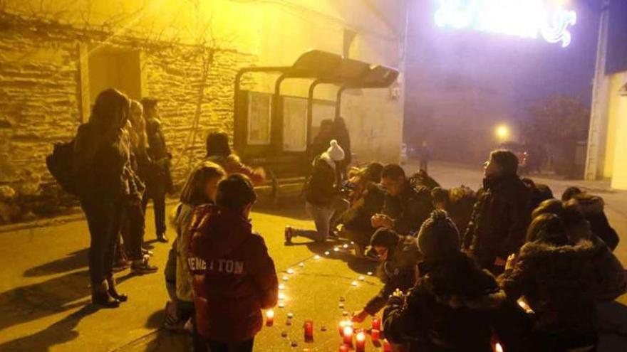 En las imágenes, dos momentos de la elaboración de la iluminación navideña vecinal, realizada por los más pequeños del barrio con velas en la plaza de la Iglesia.