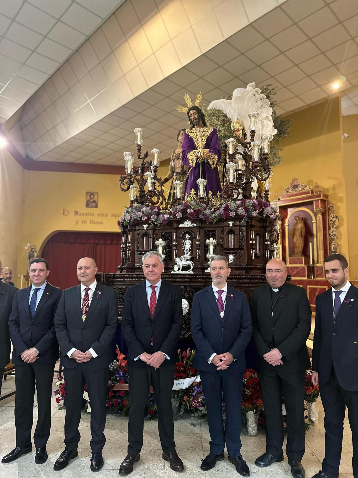 La comitiva del Ayuntamiento de Sevilla posa junto al Hermano Mayor de la Hermandad de Pino Montano frente al paso de palio.