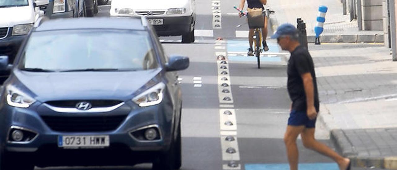 Un peatón a punto de cruzar entre los separadores del carril bici de la calle Secretario Padilla.