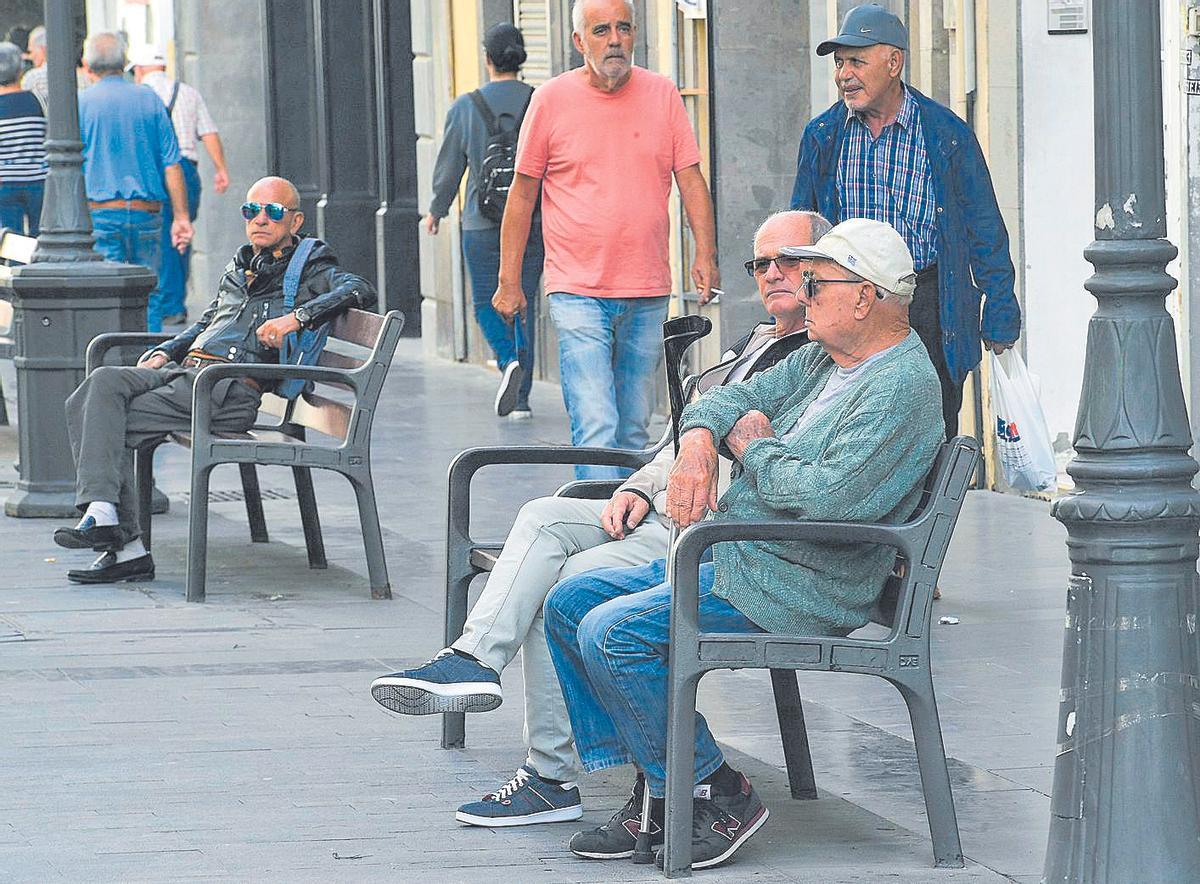 Dos jubilados descansan en un banco.
