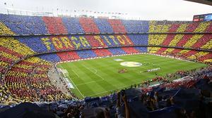 Els aficionats canten l’himne del Barça mentre formen un mosaic amb el lema ’Força, Tito!’ a les grades del Camp Nou, abans del clàssic.
