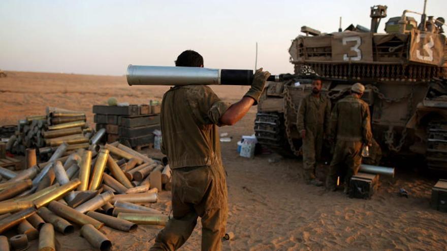 Soldados israelíes preparan un tanque Merkava, en la Franja.