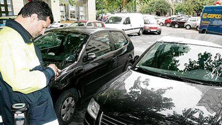 Un vigilante de la XER sanciona a un vehículo estacionado en la calle Rosalía de Castro. / jesús de arcos