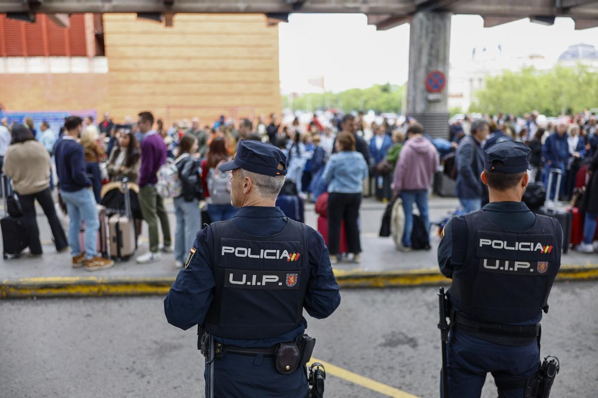 Policías observan a un grupo de viajeros afectados en Atocha.