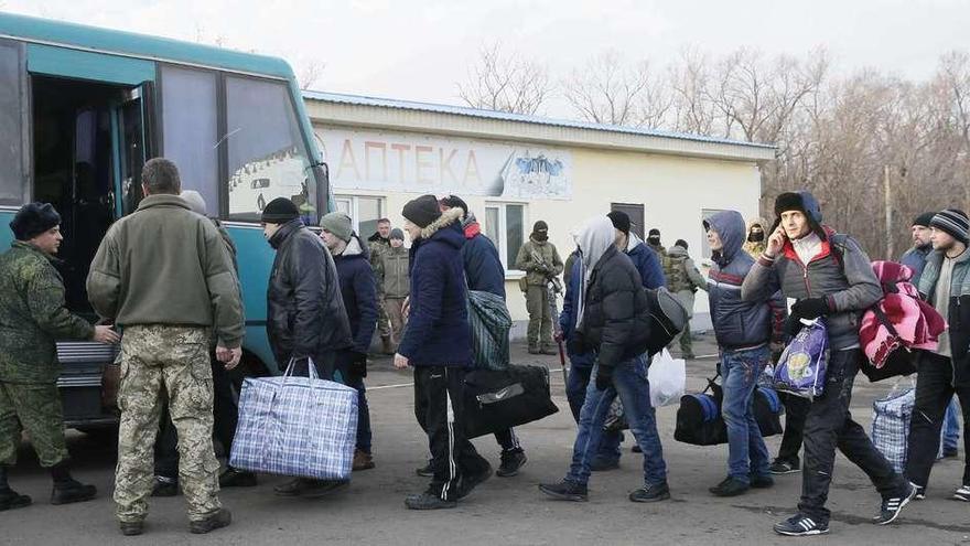 Prisioneros en manos de los separatistas de Lugansk suben a un autobús durante el intercambio. // Reuters