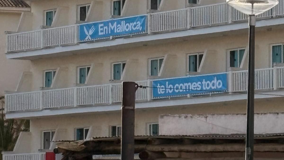 "En Mallorca, te lo comes todo", el lema de la pancarta de un hotel de Cala Rajada.