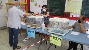 Un elector deposita su voto en un colegio electoral en Marsella, durante la segunda vuelta de las elecciones regionales francesas de este domingo.  