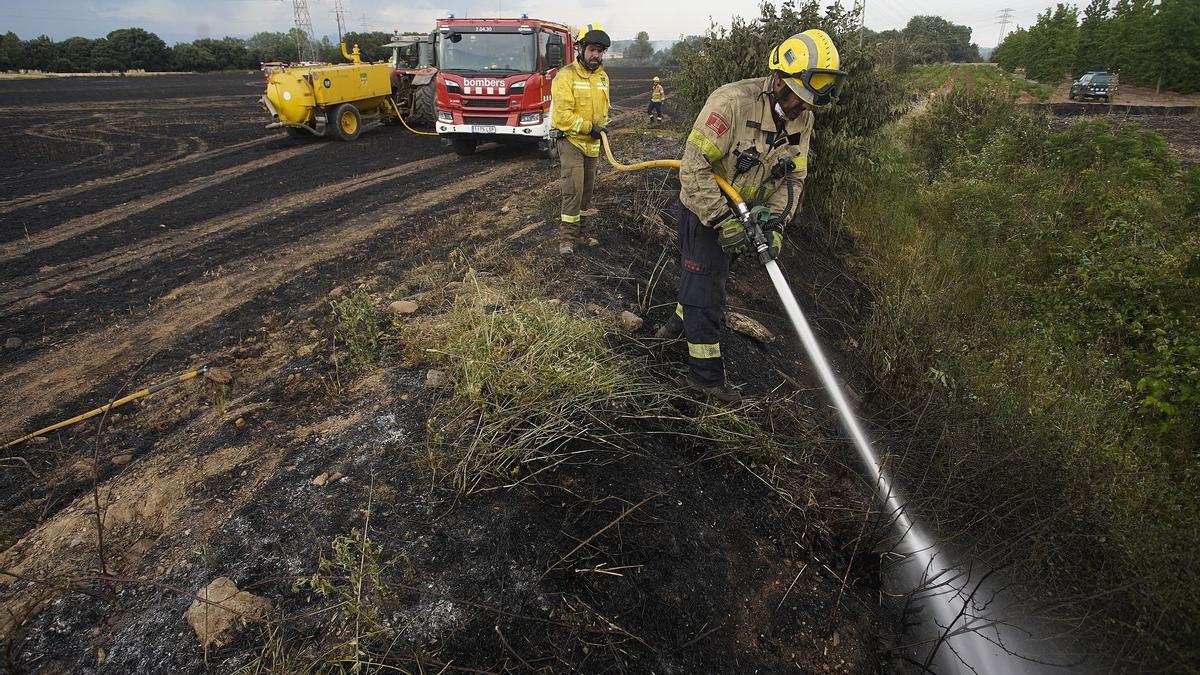 Els Bombers remullant la zona cremada