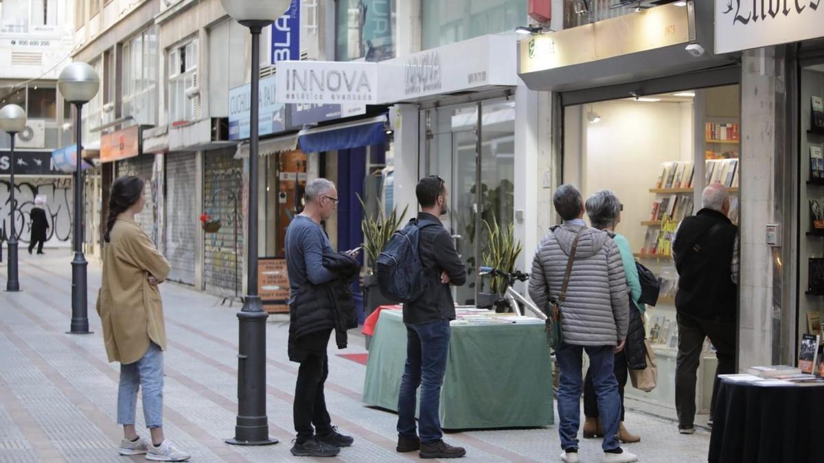 Clientes haciendo cola delante de una librería el lunes por la tarde con el sistema colapsado.