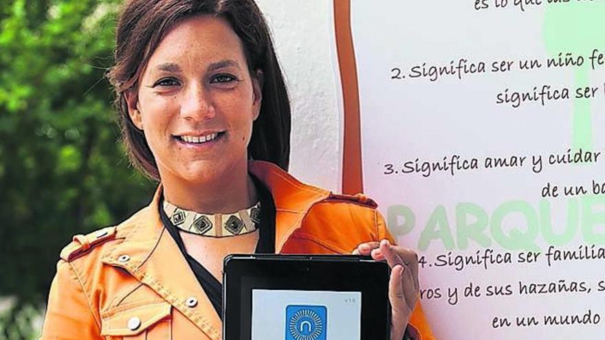 Julia Martel, este lunes, en el Parque La Laguna, en Tenerife. En su tableta, imagen de presentación de la aplicación Nudos.