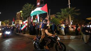 Manifestantes iranís ondean banderas de Palestina e Irán tras los ataques a Israel, la madrugada del domingo.