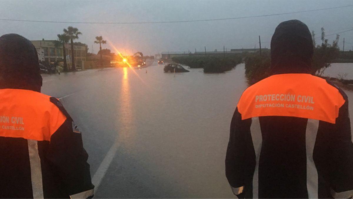 Voluntarios de Protección Civil contemplan las consecuencias de las inundaciones.