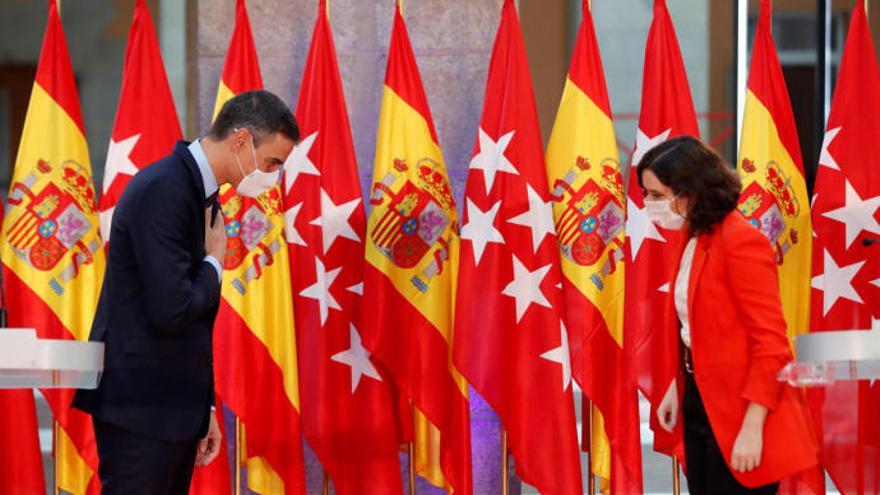 Pedro Sánchez y Díaz Ayuso se saludan en un acto institucional.