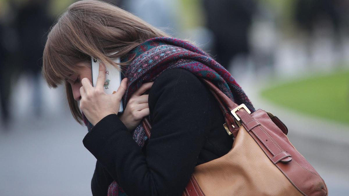 Una mujer habla por teléfono móvil.