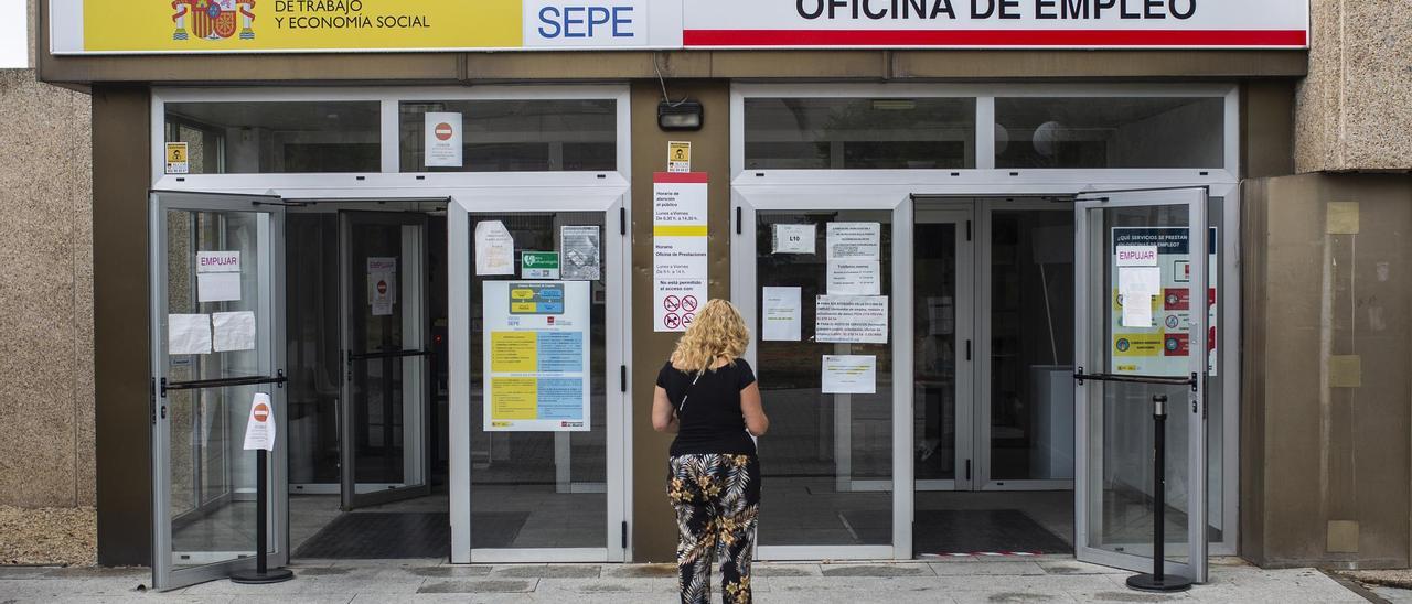 Una mujer a las puertas de una oficina del SEPE y oficina de empleo.