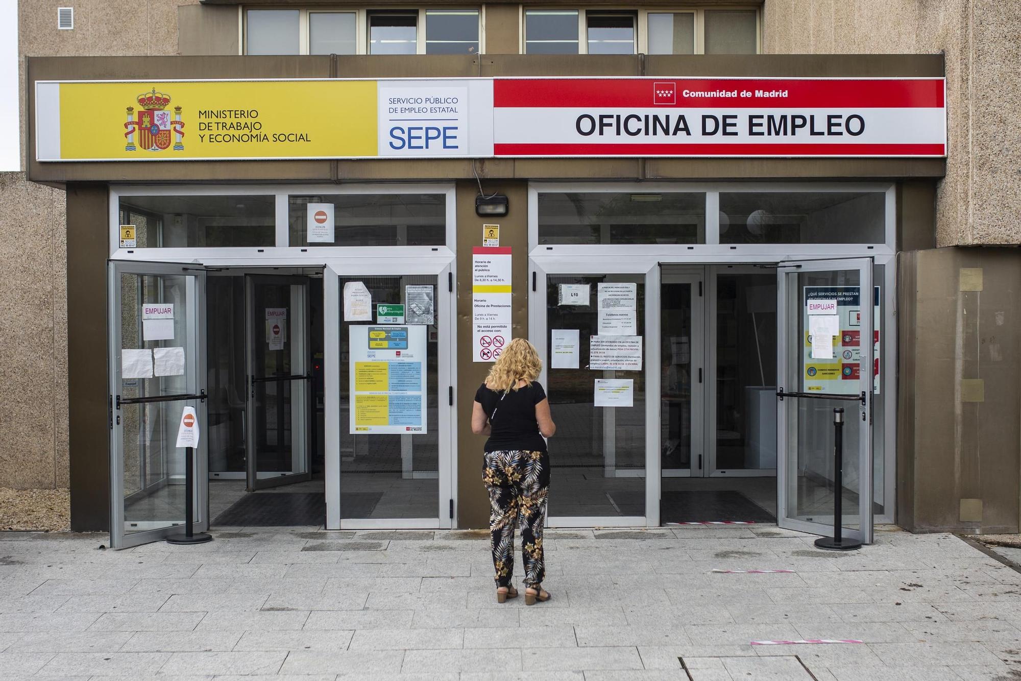 Una mujer a las puertas de una oficina del SEPE y oficina de empleo.