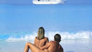 Una pareja practica nudismo en una playa de un complejo de vacaciones de lujo.