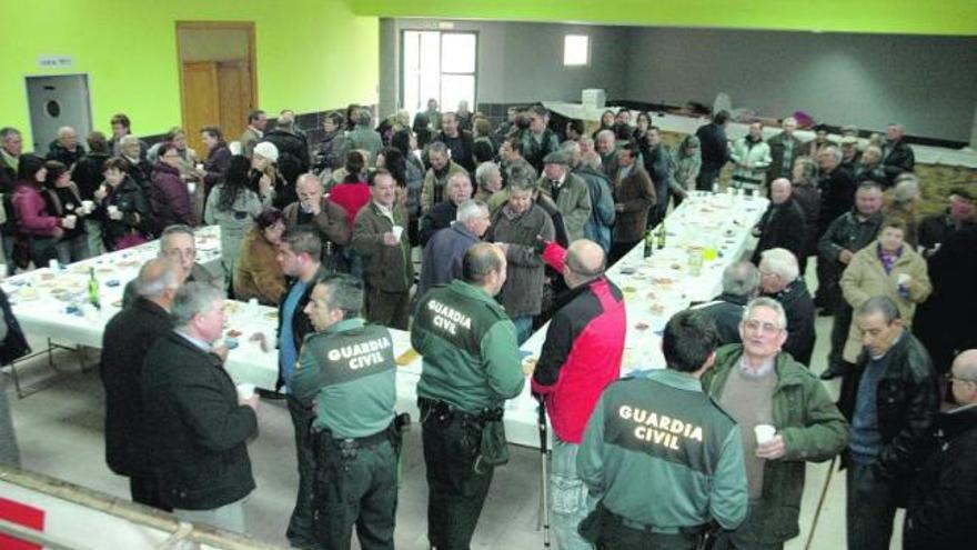 Vecinos y autoridades durante el aperitivo en el salón de actos para honrar a San Benito.