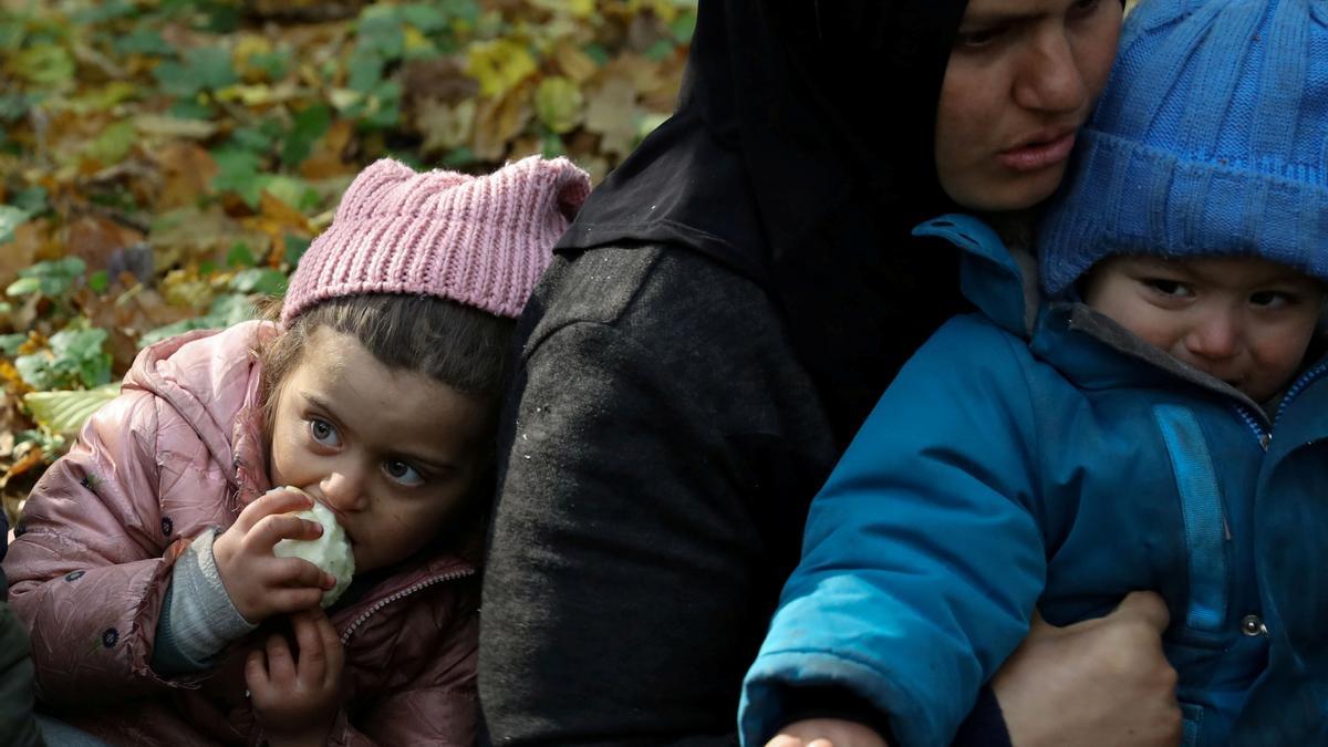 Una migrante iraquí con sus dos hijos, permanece retenida por la policía de fronteras de Polonia después de cruzar desde Bielorrusia, el pasado 14 de octubre.