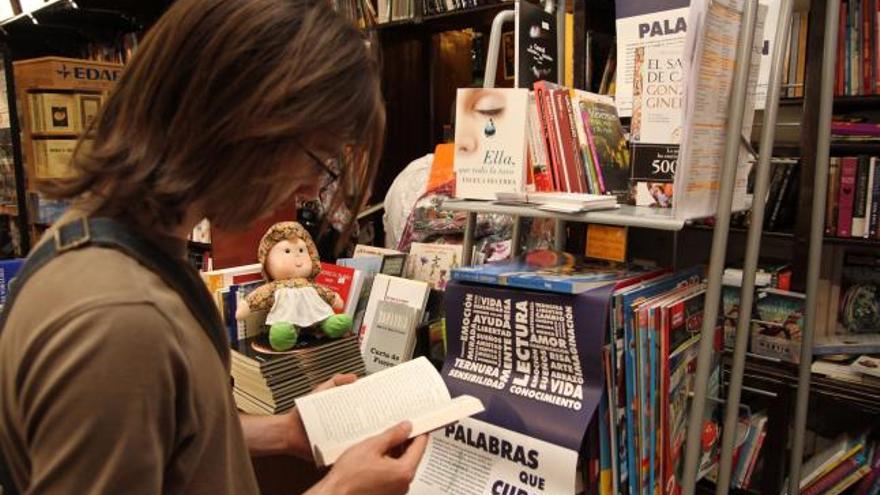 Un joven ojea un libro de los apadrinados en el proyecto «Palabras que curan» en una librería de la capital.