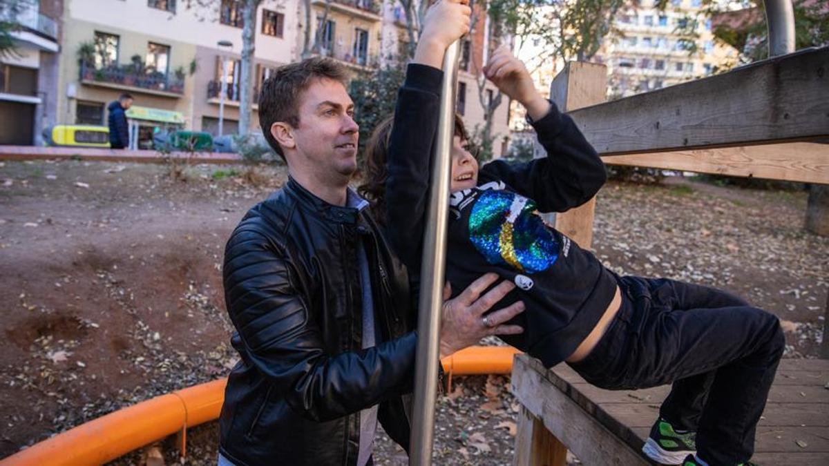 Un hombre juega con su hija en un parque de Barcelona.