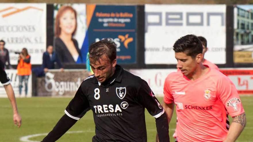 Adrián Llano conduce el balón ante un defensa de la Cultural.