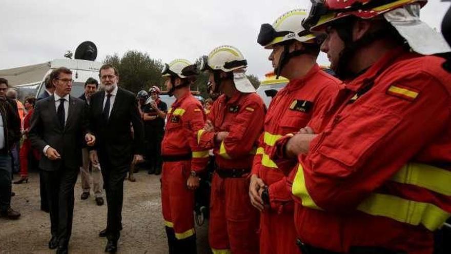 Feijóo y Rajoy, ayer, con efectivos de la UME en Pazos de Borbén; vecinos observan las llamas en Los Ancares, y movilización contra los incendios, ayer noche, en Orense.