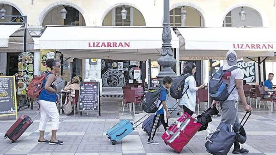 Turistas con maletas en la Plaza Mayor de Palma.