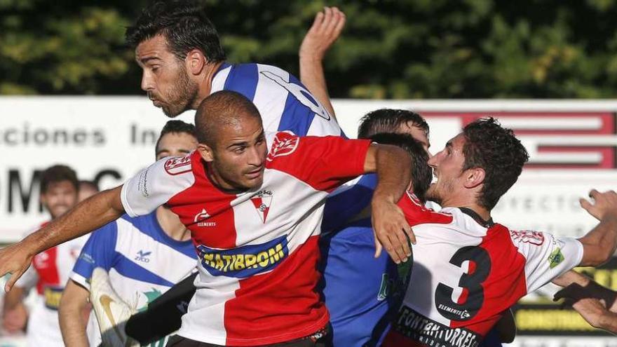 Varios jugadores del Arosa y del Areas disputan un balón durante el encuentro de ayer en el campo de A Lomba.