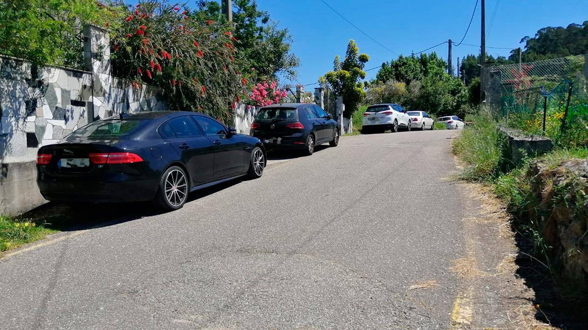 Coches mal estacionados en el acceso a la playa de Areabrava, en Hío.